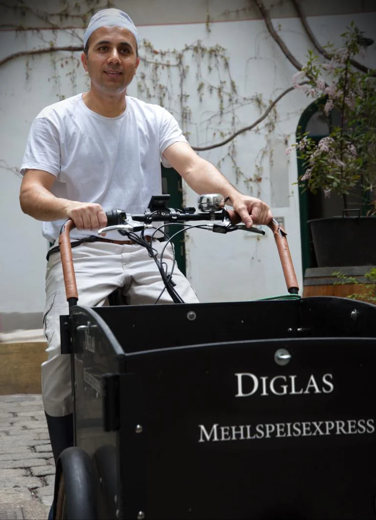 Ein Mitarbeiter der Backstube Diglas mit dem Mehlspeisenexpress im Wiener Innenhof